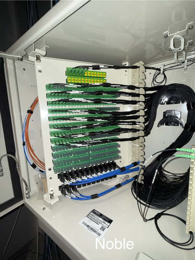 Open telecommunications cabinet with organized fiber equipment and cabling