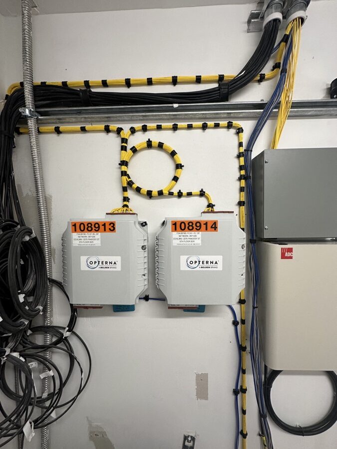 Fiber distribution enclosures beneath dressed yellow and black cable runs