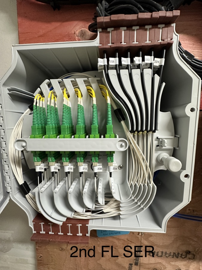Open splice enclosure with symmetrical white fiber routing and green adapters